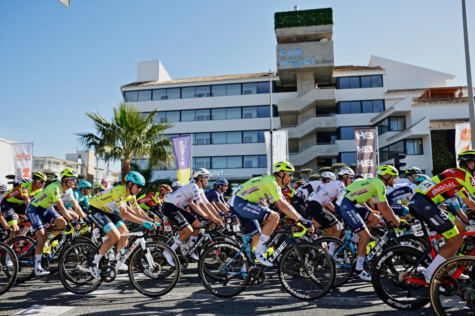A professional peloton riding past Hotel Cap Negret in Altea